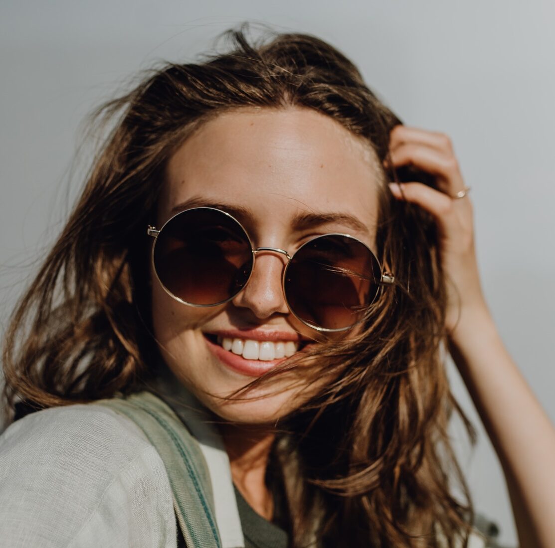 Portrait of happy young woman outdoor with backpack and sunglasses.